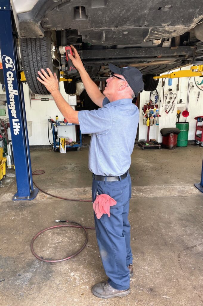mechanic looking under car